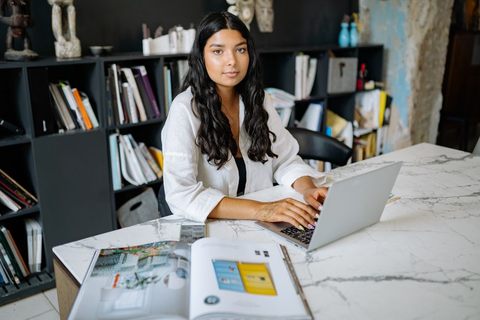 Indian woman working on a laptop at home, looking at AI training platform options