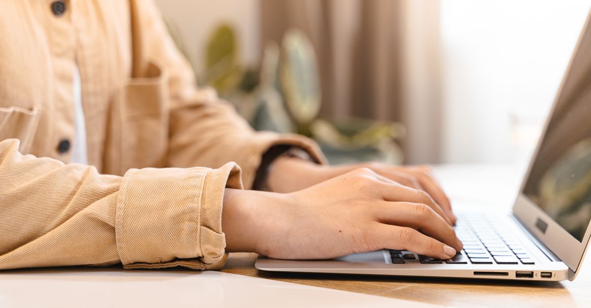 Hands typing on a laptop while completing AI training tasks from India