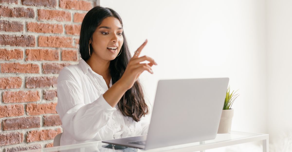 Indian woman working at a laptop, checking whether a payment from an AI platform has arrived