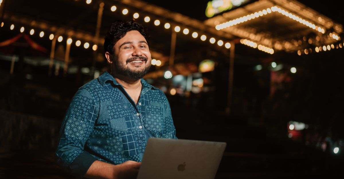 Indian man working on a laptop, using written English for online work