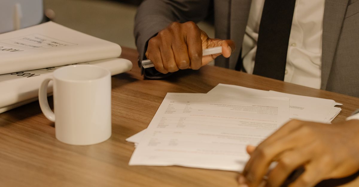 Hands sorting remittance paperwork and FIRA documents for foreign income in India