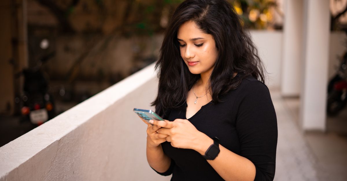 Indian woman checking her phone, where the annual information statement lists TDS