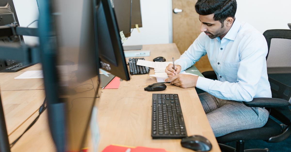 Man at an office workstation, the hybrid metro setup behind half of FlexJobs India listings