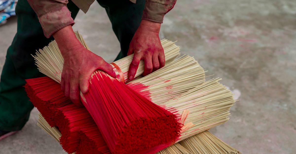 Hands bundling incense sticks, the packing work sold to homemakers in the Haveri scheme.