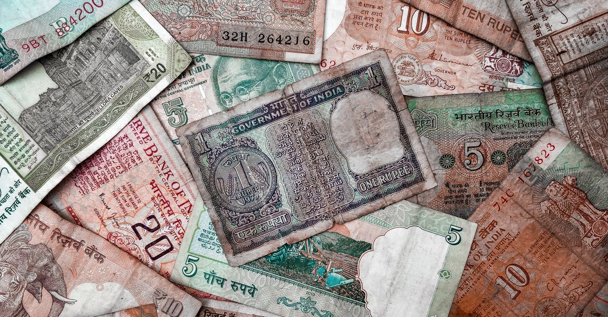 Spread of Indian rupee notes representing the small deposit a job scam asks for first