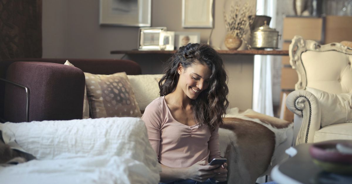 A woman sitting at home using her phone